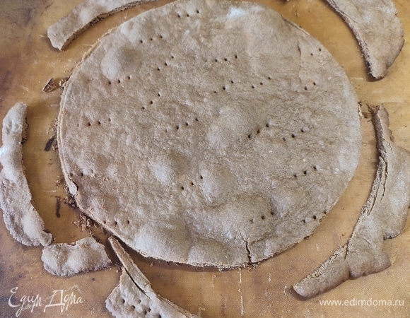 Каждый шарик тонко раскатать, наколоть вилкой и выпекать 5–7 минут при температуре 180°C. Еще горячий корж обрезать по форме.