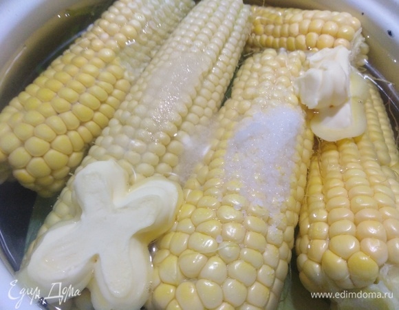 На листья выложить кукурузу. Довести до кипения. Добавить соль, сахар, масло. Варить 15 минут.
