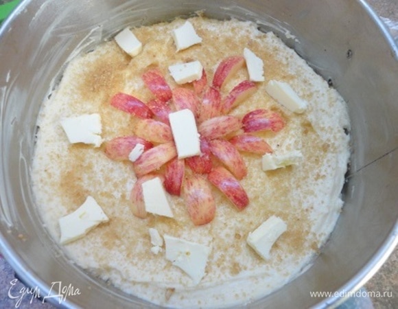 Муку с разрыхлителем просеять к масляной смеси, перемешать и выложить на яблоки. Поверхность разровнять, посыпать сахаром и орехами. Яблоки — это уже мое личное пожелание. В оригинале рецепта этого нет. И сверху распределить кусочки сливочного масла. Выпекать 35–40 минут. Ориентируйтесь по своей духовке.