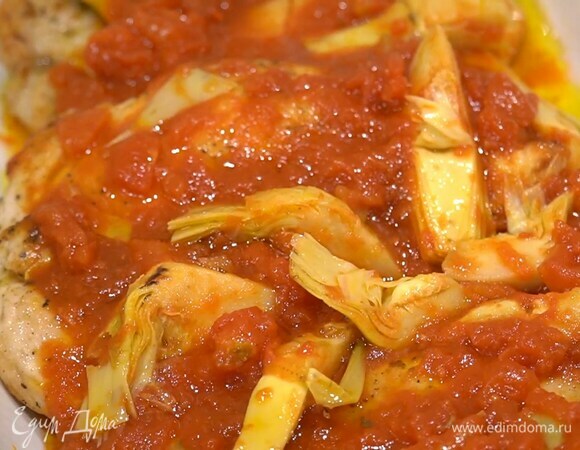 В жаропрочную керамическую форму выложить обжаренный лук и чеснок, индейку, помидоры с артишоками и запекать в разогретой духовке 10–15 минут.