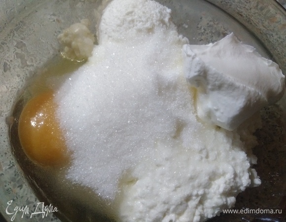 В творог добавить яйцо, сахар, сметану. Перемешать.