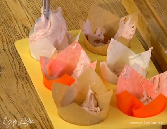 Разложить тесто в формы для кексов с бумажными вкладками, заполняя их на 2/3 объема.