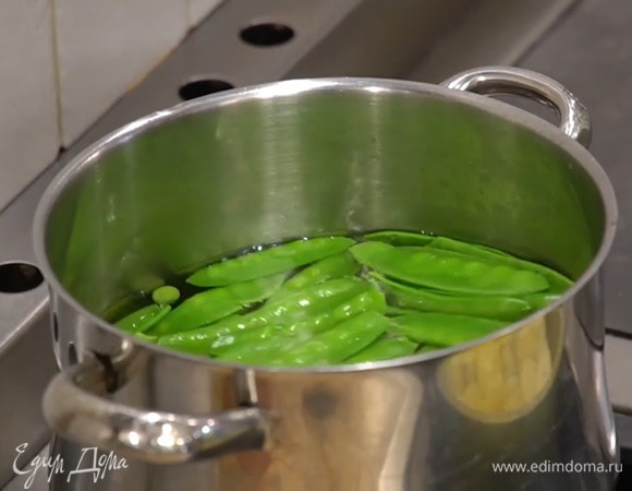 В глубокой кастрюле вскипятить воду, опустить на 2 минуты стручки фасоли, затем вынуть, а в кастрюлю выложить стручки гороха и размороженный зеленый горошек, дать воде закипеть и слить ее, поместить весь горох на лед, затем промокнуть бумажным полотенцем.