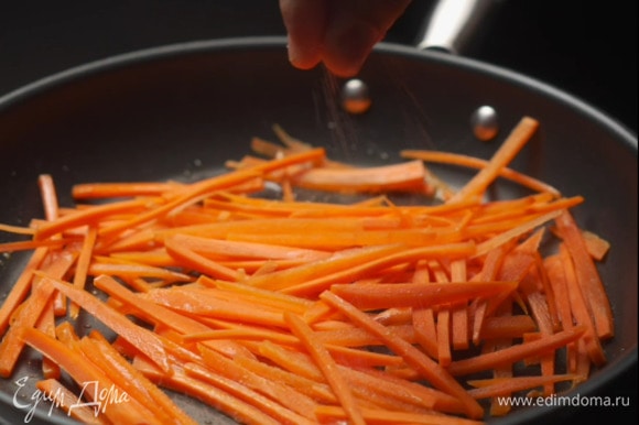 Морковь выложить на сковороду, слегка посолить.