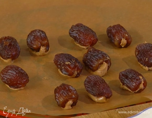 Финики разрезать вдоль, добавить в каждый по чайной ложке миндальной пасты и выложить на бумагу или фольгу.