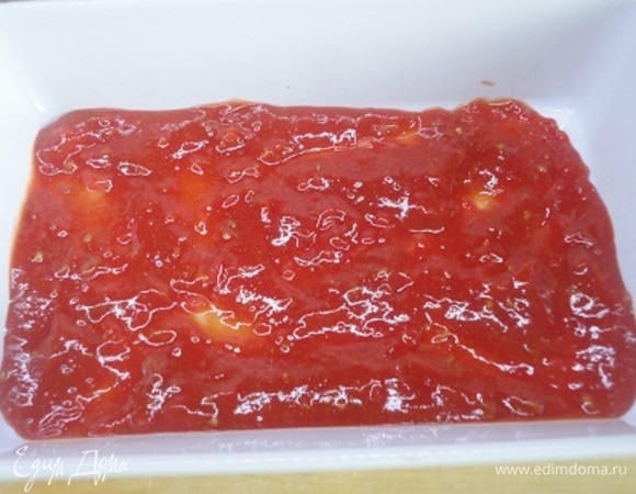 Распределяем 1 стакан соуса по дну формы для запекания.