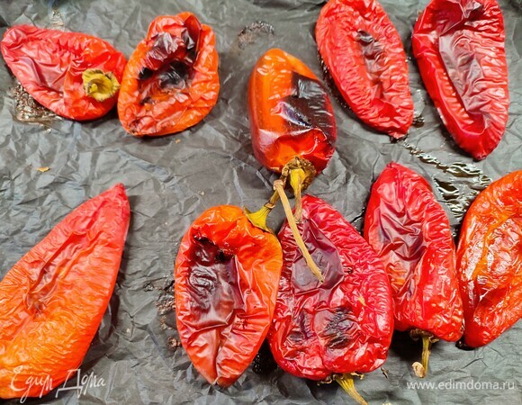 Перец вымыть и выложить на противень, застеленный бумагой. Запекать 25 минут при температуре 250°C до зарумянивания.