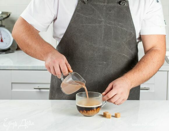 В чашку со свежесваренным кофе влейте молочно-шоколадную смесь, по желанию добавьте сахар.