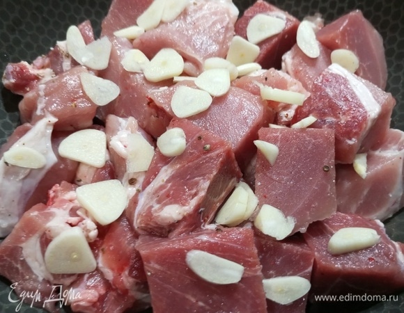 Мясо нарезать на крупные куски, посолить, посыпать перцем и чесноком. Выложить в форму. Накрыть фольгой. Поставить в разогретую духовку.