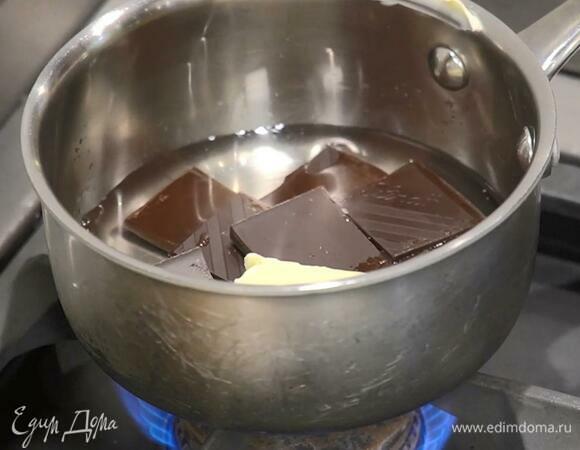 Шоколад поломать кусочками, выложить в ковшик, добавить 50 г сливочного масла, влить 120 мл кипяченой воды и растопить на медленном огне.
