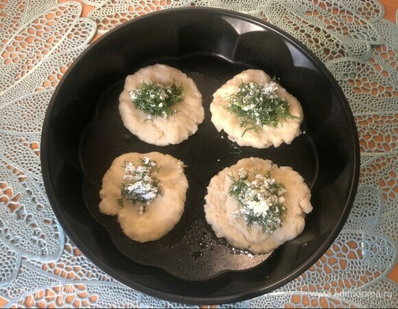 Разрезать немного остывшую поленту на равные кружочки (лепешки). На серединку выложить начинку из творога и зелени.