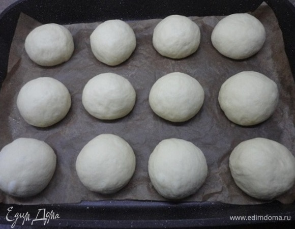 Разделите тесто на 12 равных частей (используйте весы), сформуйте булочки, выложите на противень и оставьте в теплом месте для подъема. Включите духовку для разогрева на 180–200°C (ориентируйтесь по своей духовке).