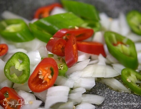 Разогреть в сковороде оливковое масло и обжарить лук и чили.