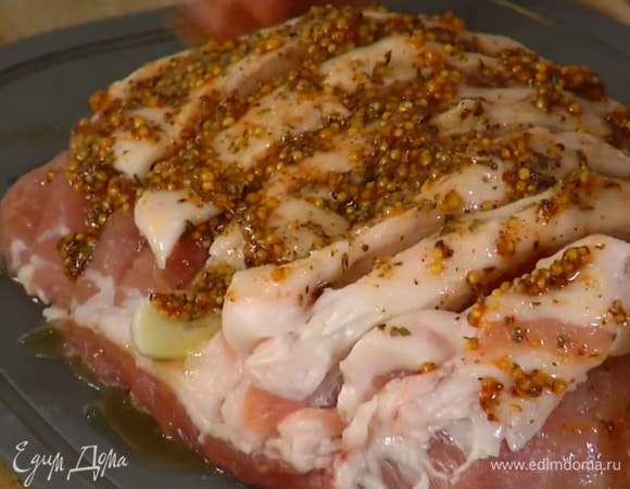 Карбонад надрезать кусками толщиной в 1 см, не прорезая до конца, между кусками мяса вложить чеснок и смазать все маринадом.