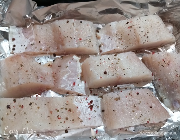 Форму застелить фольгой. Выложить куски рыбы. Посолить, посыпать перцем, сбрызнуть соком лимона.