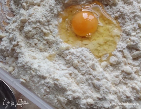 В центр массы добавить яйцо, которое до этого момента находилось в холодильнике. Добавить ледяную воду. Перемешать, долго не перемешивать, чтобы тесто меньше соприкасалось с теплыми руками.