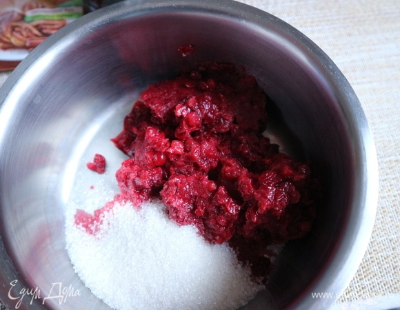 Размять бруснику с сахарным песком.