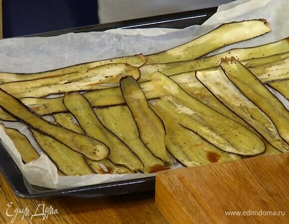 Противень выстелить бумагой для выпечки, полить оставшимся оливковым маслом, выложить баклажаны, слегка посолить и поперчить, затем поместить в разогретую духовку до 220°С, понизить температуру до 200°С и запекать 10 минут.