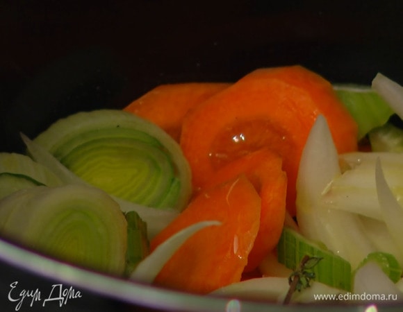 В чашу мультиварки влить половину растительного масла, выложить порей, сельдерей, лук, морковь и готовить на программе «жарка».