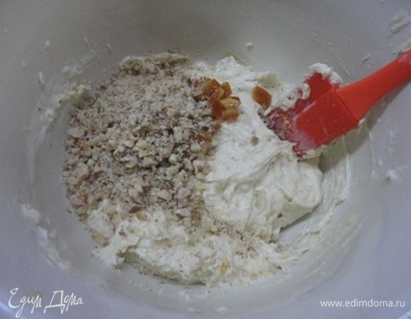 Мягкое сливочное масло взбить с сахарной пудрой в пышную массу. Два мелких или одно крупное яйцо (отборной категории) добавить, продолжая взбивать. Соединить с кефиром, цукатами и рублеными орехами. Перемешать. Всыпать сухие ингредиенты и снова перемешать.