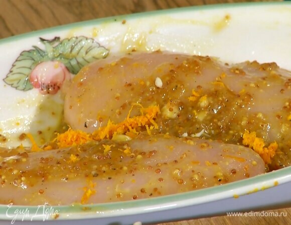 Грудки разрезать сбоку, не прорезая до конца, и поместить их в жаропрочную форму, посолить попречить сверху выложить варенье, горчицу, чеснок, цедру апельсина, полить оливковым маслом и равномерно распределить все по поверхности курицы и внутри, сверху положить веточки тимьяна.