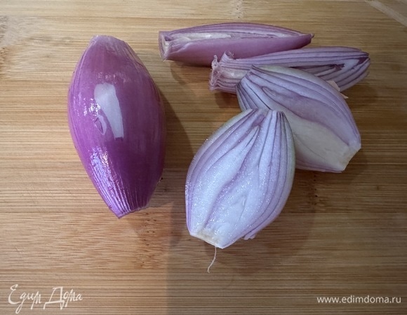 Очистите лук-шалот и разрежьте его пополам.