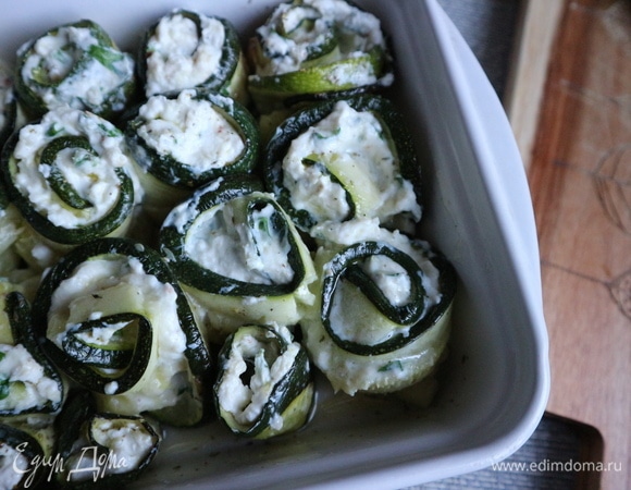 На пластины цукини равномерно разместить начинку, скрутить рулеты.