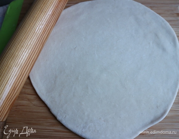 Начать раскатывать тесто от центра к краям.