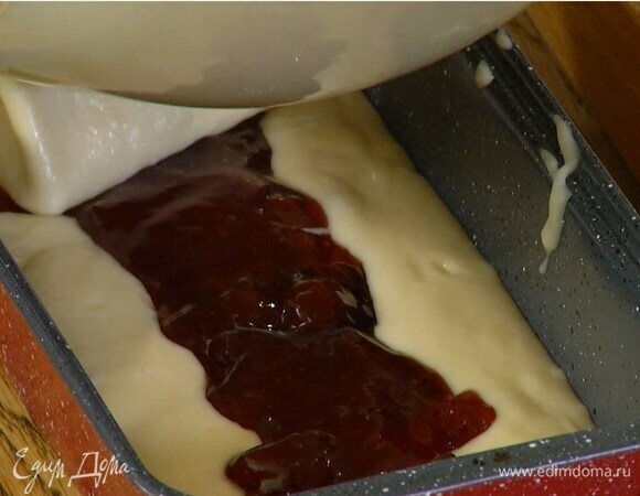 В форму для кекса выложить половину теста, в длину по центру выложить дорожку джема, сверху равномерно распределить оставшееся тесто.