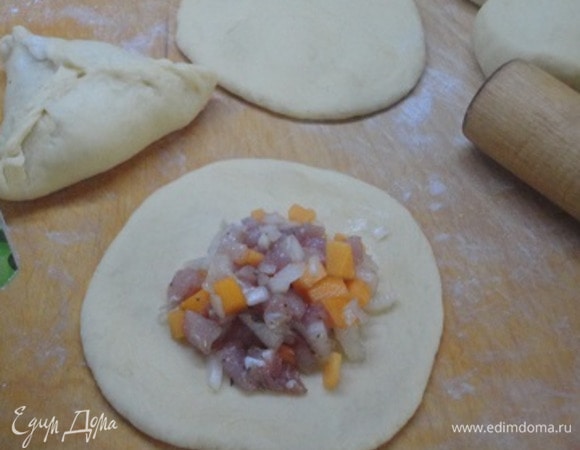 Каждый кусочек раскатываем в круг и выкладываем по 1 ст. ложке (с горкой) начинку. Защипываем, придавая изделию форму треугольника.