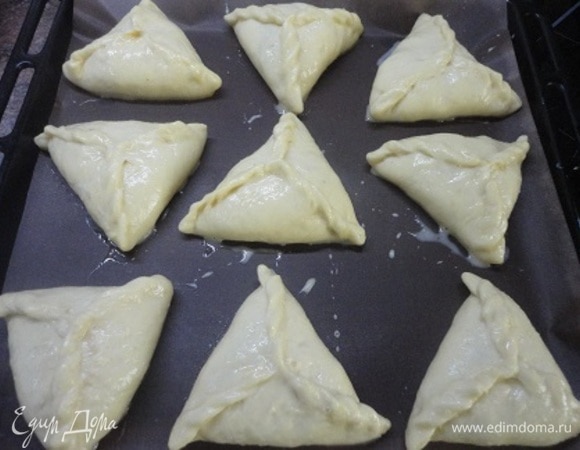 Выкладываем на противень и смазываем смесью желтка с 1 ст. л. молока. Включаем духовку для разогрева на 180°C.