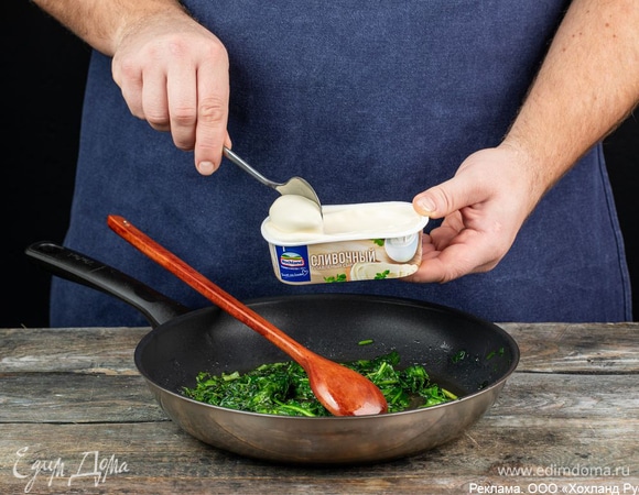 Добавьте к шпинату плавленый сыр Hochland «Сливочный». Он придаст начинке сливочно-сырный вкус и нежную кремообразную консистенцию. Перемешайте и держите на огне еще 2 минуты.