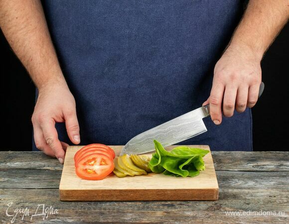 Нарежьте на кружки помидоры и огурцы, помойте и обсушите салат.