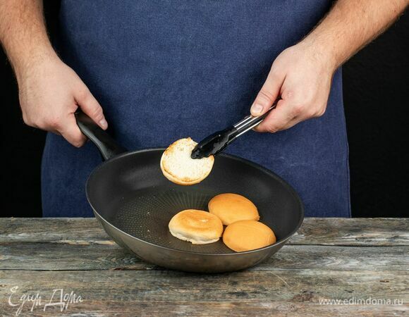 Разрежьте булочки пополам и прогрейте на сковороде.