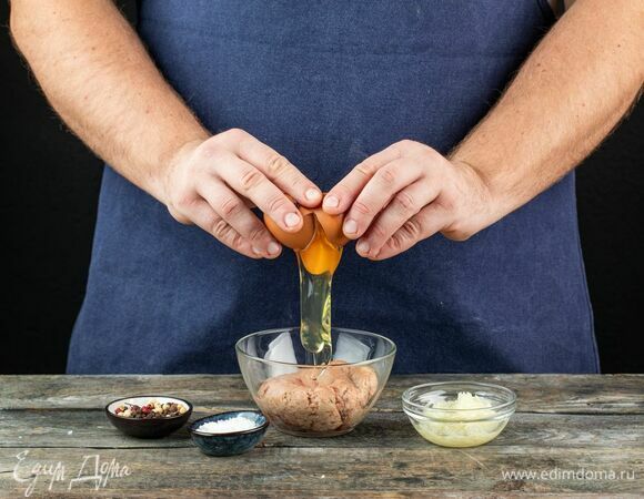 В глубокой миске соедините фарш, яйцо, обжаренный лук и специи.