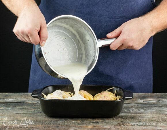 Возьмите форму для выпечки и сформируйте «гнезда» из готовой пасты. В каждое положите тефтельки. Сверху полейте блюдо сливочным соусом.