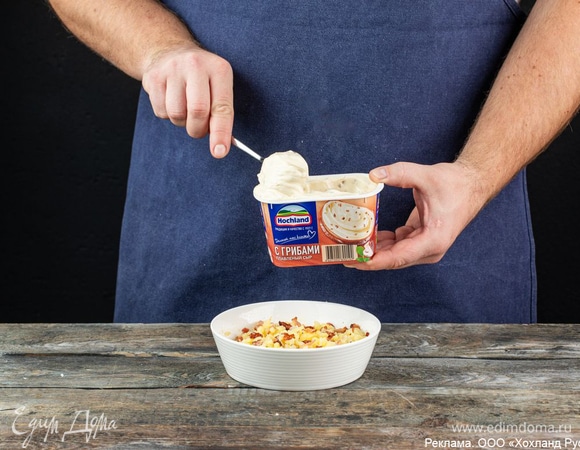 Выложите картофельную мякоть в глубокую миску и разомните вилкой. Добавьте к ней обжаренный бекон и плавленый сыр Hochland «С грибами». Плавленый сыр придаст блюду особую нежность и сливочность. Крупные кусочки настоящих грибов отлично сочетаются с картофелем и беконом. В итоге блюдо получится еще ярче и ароматнее.