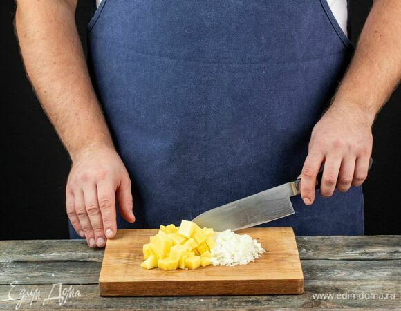 Мелко нарежьте лук, а картофель очистите и нарежьте кубиками.