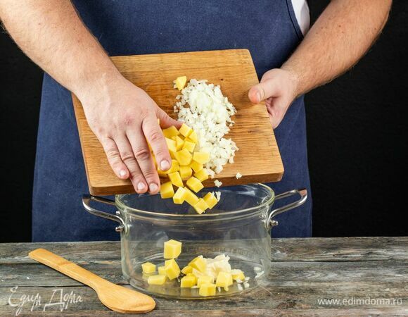 В кастрюле растопите сливочное масло на среднем огне. Добавьте лук и картофель, обжарьте до мягкости.