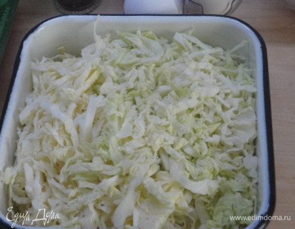 Включите духовку для разогрева до 180°С. Очень тонко нашинкуйте капусту, посолите и слегка пожмите руками. Оставьте на 10 мин.