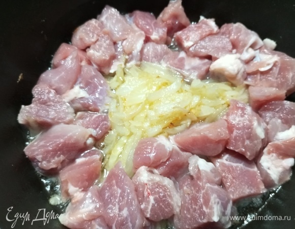 Выложить куски мяса по краю казана, чтобы лук оставался в центре.