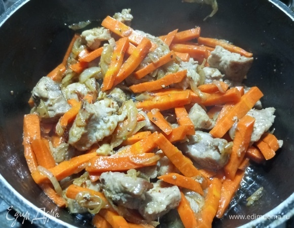 Всыпать нарезанную брусочками морковь. Добавить зиру, шафран и перец. Жарить 5–7 минут.