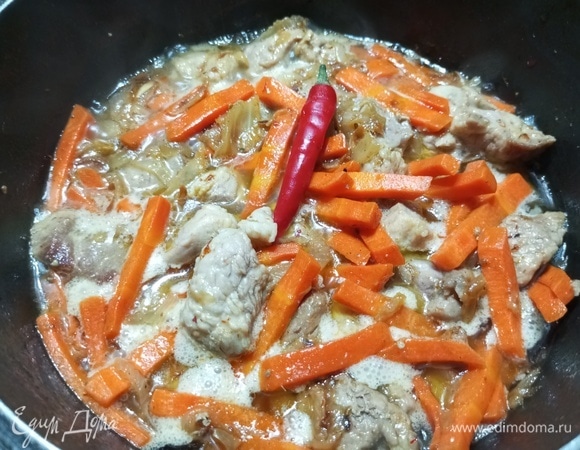 Влить кипяток до уровня мяса и моркови. Положить острый перец и соль. Тушить зирвак 5–7 минут.