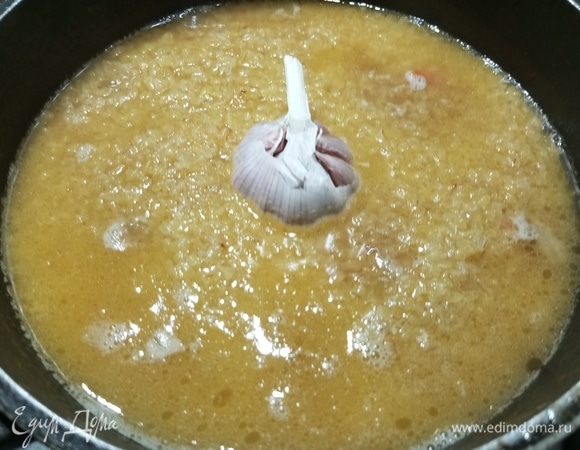 Залить кипятком до уровня крупы. В центр поместить головку чеснока. Готовить под крышкой на тихом огне 10 минут.