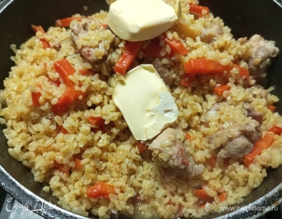 Убрать крышку с казана. Плов перемешать, добавить сливочное масло.