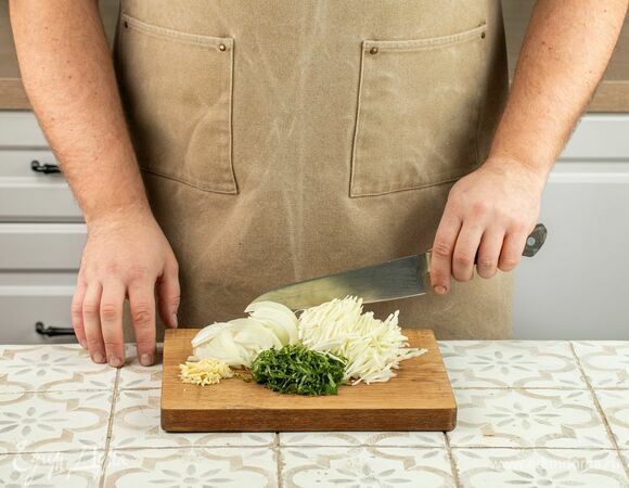 Нашинкуйте капусту, нарежьте лук тонкими кольцами, чеснок и зелень измельчите произвольно.