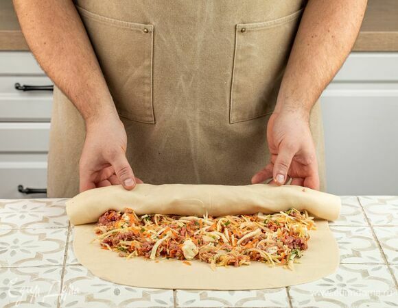 Раскатайте тесто в тонкий пласт. Для удобства тесто можно разрезать на несколько частей. Распределите по тесту начинку, скатайте в рулет. Готовьте в пароварке 45 минут, смазав лист пароварки сливочным маслом.