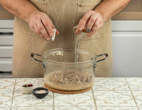 Влейте в кастрюлю воду, положите сливочное мало и поставьте на огонь. Томите под крышкой на среднем огне в течение 1 часа. По прошествии времени добавьте к мясу измельченный чеснок, черный перец, соль и уксус. Оставьте томиться еще на 60 минут.