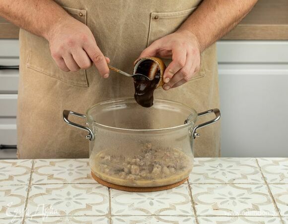Разомните томленое мясо вилкой, полейте соусом барбекю, перемешайте.