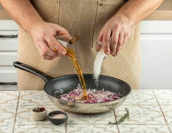 Нарежьте лук тонкими полукольцами. Разогрейте в сковороде оливковое масло, выложите лук, переведите плиту на средний уровень нагрева, томите лук до мягкости. Влейте коньяк, добавьте сахар, соль, перец и тимьян. Готовьте до испарения жидкости, помешивая, 30 минут. Дайте остыть.